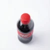 Bouteille en plastique d'AMERICAN COLA 35 cl en vue de dessus, avec son bouchon rouge vif et son étiquette rouge sur fond blanc.