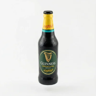 Vue de face de la BIERE EN BOUTEILLE PETITE GUINNESS 33CL, une bouteille en verre noir avec étiquette verte et coiffe jaune.