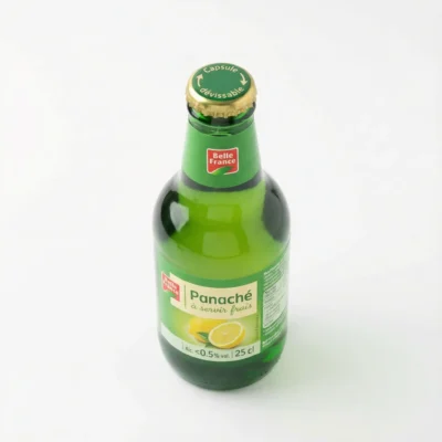 Vue de dessus de la BIERE PANACHE BELLE FRANCE 25 cl dans sa bouteille en verre vert, avec sa capsule dorée et son étiquette citron.