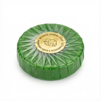 Bloc désodorisant assortis de forme ronde et verte, vue de face, sous un emballage plastique avec une étiquette dorée centrale.