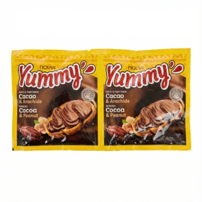 Vue de face de deux sachets plastiques jaunes du CHOCOLAT YUMMY 30G 36, montrant la pâte à tartiner cacao et arachide.