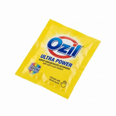 Sachet jaune rectangulaire du détergent Ozil Ultra Power 25g, photographié en vue de dessus sur un fond blanc.