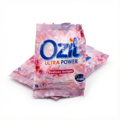 Vue latérale du sachet rose du détergent Ozil Ultra Power Floral 25g, avec son logo bleu et son design floral sur fond blanc.