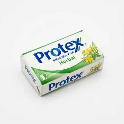 Vue de dessus du savon PROTEX PHARMAPUR HERBAL 150G dans son emballage papier blanc, vert et bleu orné de fleurs jaunes.