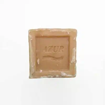 Vue de dessus du SAVON AZUR 350G, un carré de savon beige artisanal avec le nom AZUR estampé au centre, sur fond blanc.