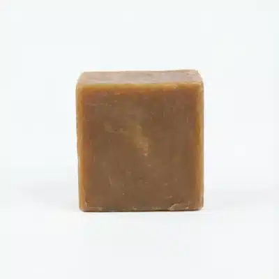 Vue de arrière du SAVON SANET 700G, un bloc cubique marron à la surface marbrée, posé sur un fond blanc.
