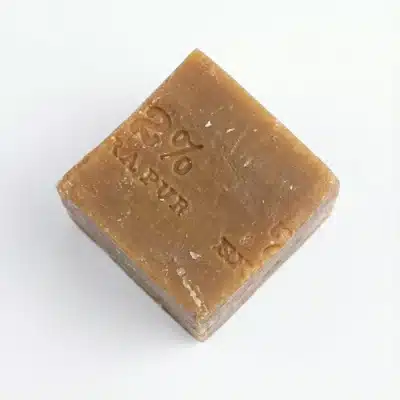 Vue de dessus du SAVON SANET 700G, un cube de savon brun-ocre avec des inscriptions en relief, sur un fond blanc uni.
