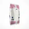 Vue de côté du sachet rose et blanc de sucre SOSUCAM 1kg blanc, montrant le code-barres et les instructions du produit.
