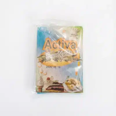 Vue de dessus du sachet de SUCRE VANILLE ACTIVA 11G dans son emballage plastique, avec des illustrations de desserts sur fond bleu.